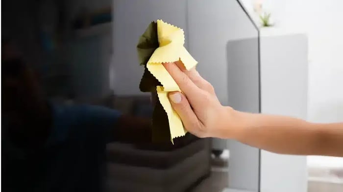 wiping dust off the TV before storage