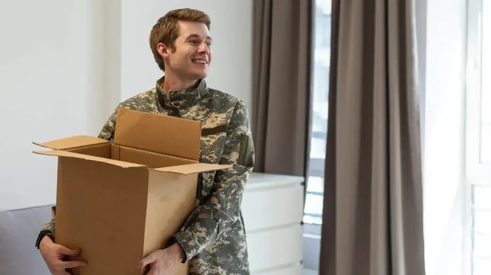a serviceman holding a moving box