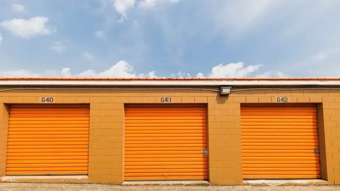 A picture of three orange storage unit doors at the Mini Mall Storage facility