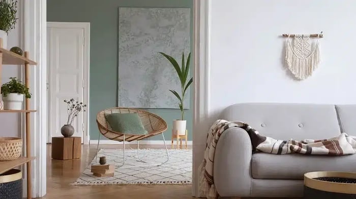 A living room with a couch and a chair, there is also decor on the walls and plants.