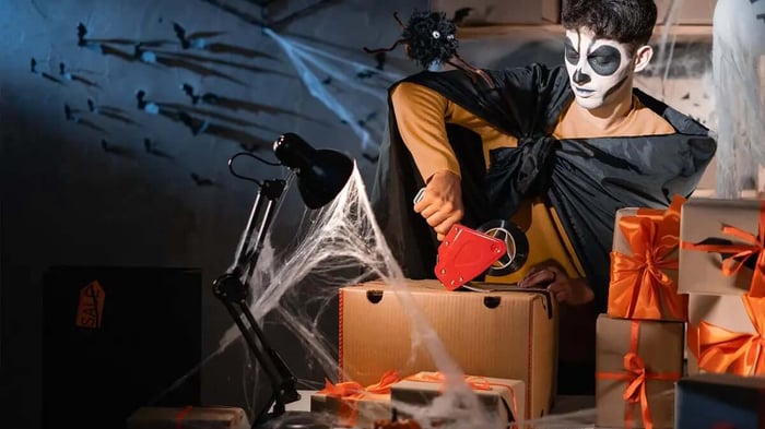 a man in a Halloween costume packing decorations