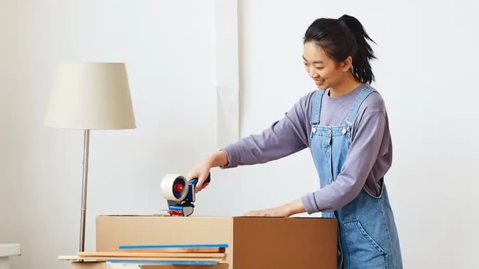 A woman packing a box to take to her self storage unit with Mini Mall Storage