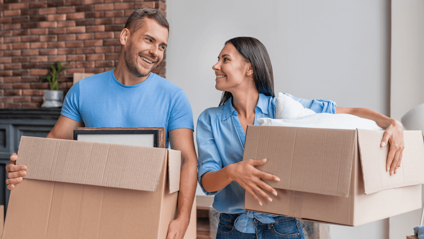 Two people packing household boxes before moving belongings into storage