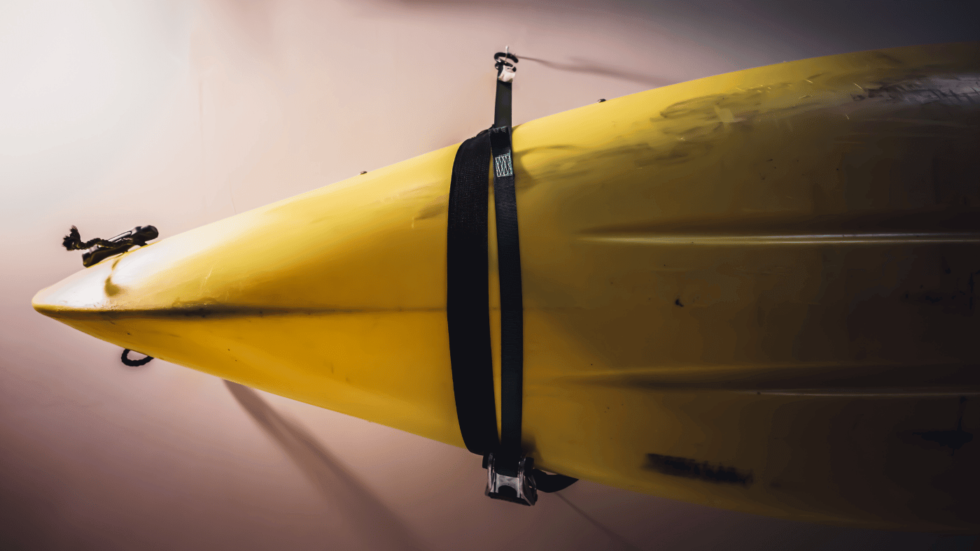 Yellow kayak supported horizontally on a wall-mounted storage rack