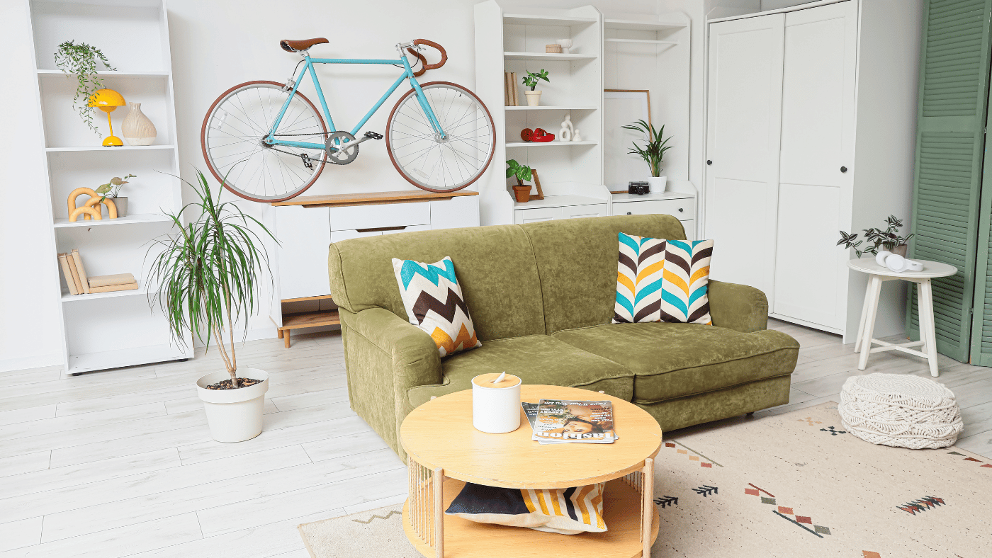 Wall-mounted bicycle and tall shelving creating vertical storage in a small apartment