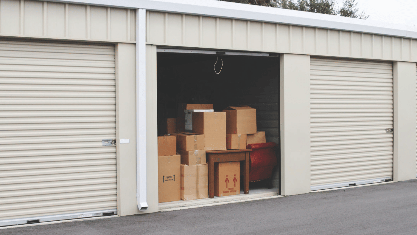 Labeled moving boxes arranged inside an organized storage unit with a clear walkway