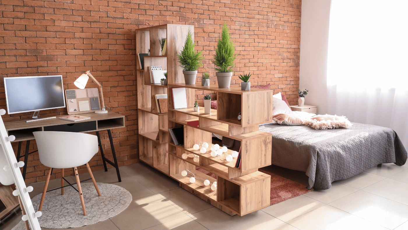 Open shelving used as a room divider between sleeping and living areas in a studio apartment