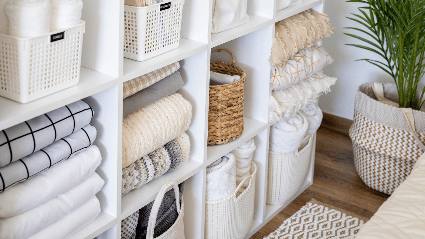 Organized shelving with baskets, folded linens, and labeled storage containers