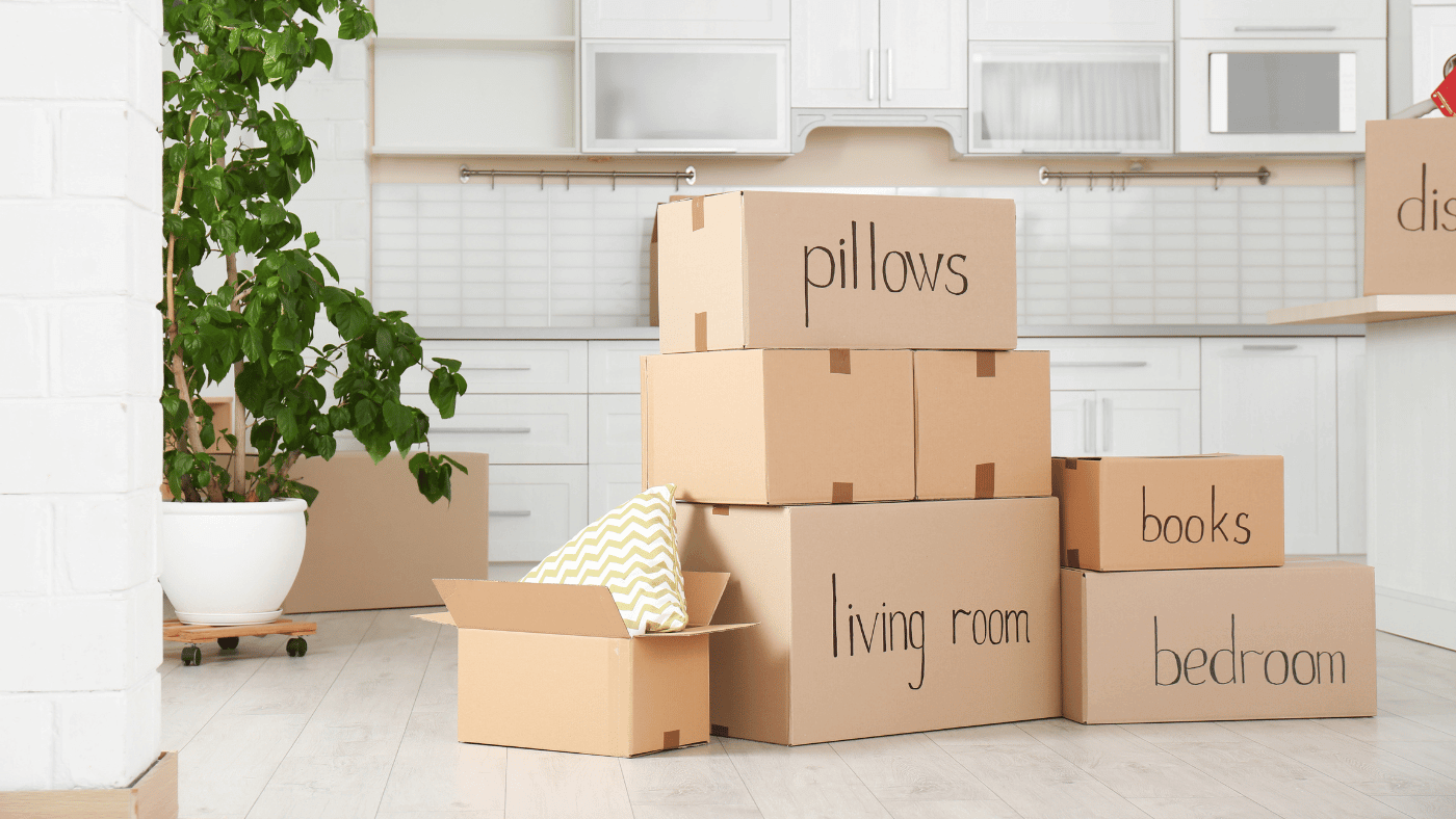 Moving boxes labeled by room and organized for temporary storage