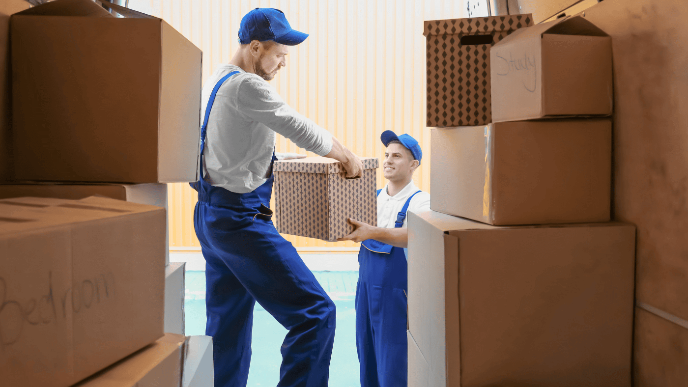 Movers carrying packed boxes during a temporary storage transition